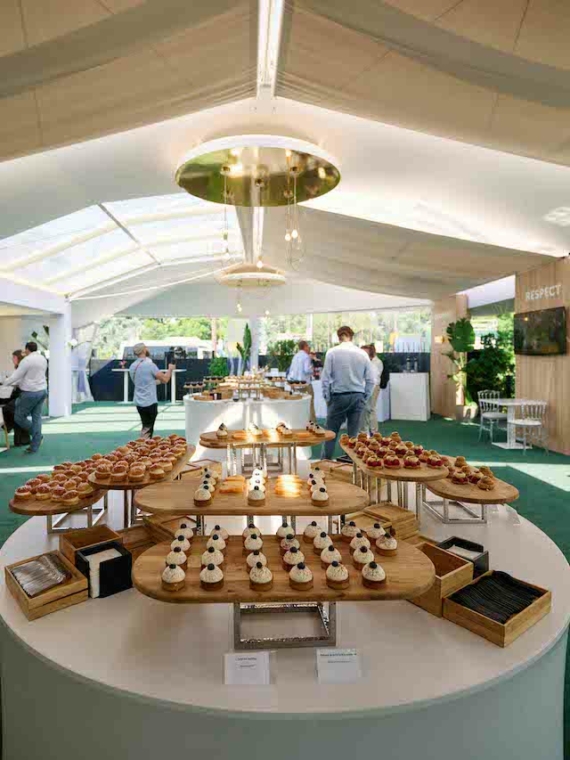 Intérieur de l'espace VIP Pavillon Roland-Garros avec les tables des invités et un buffet de délicieux petits four
