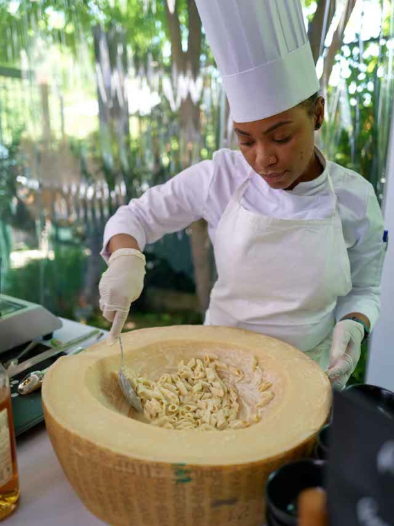 A chef prepares Italian pasta in a cheese wheel at the Pavillon during Roland-Garros