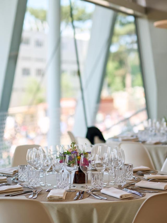 Une table dressée au Salon Légende de Roland-Garros avec une vue sur la baie vitrée