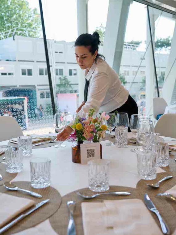 Une serveuse qui prépare une table VIP au Salon Légende pendant Roland-Garros