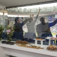 Des clients hospitalités qui profitent d'un match dans une loge premium au Stade de France et des services hospitalités comme le buffet culinaire