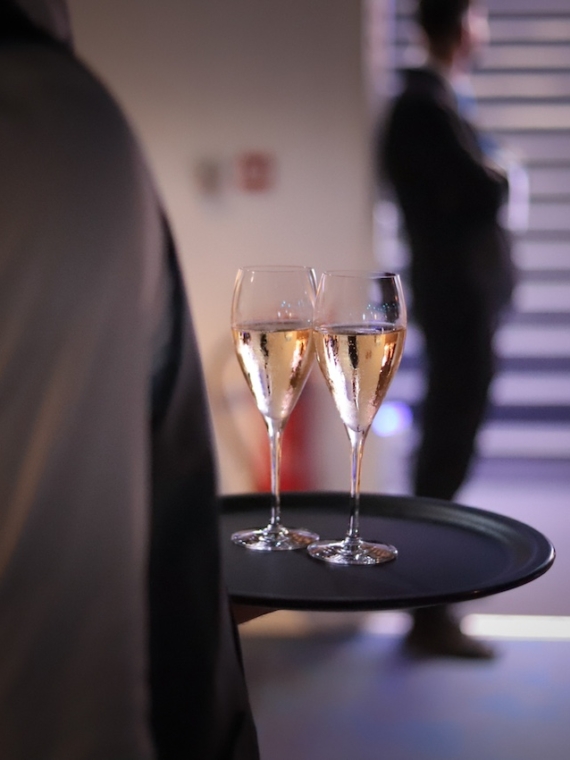 Un serveur proposant du champagne lors du repas assis au Salon Partagé proposé par Sodexo Live Hospitality