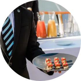 3200 evenements chaque annee.png Serveur qui tient des petits fours pendant une réception hospitalité