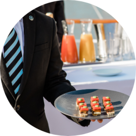 3200 evenements chaque annee Serveur qui tient des petits fours pendant une réception hospitalité