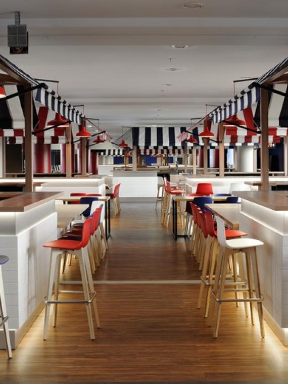 Shared lounge at Groupama Stadium's Salon des Lumières, offering a convivial atmosphere inspired by Lyon's famous Halles, with panoramic views of the pitch