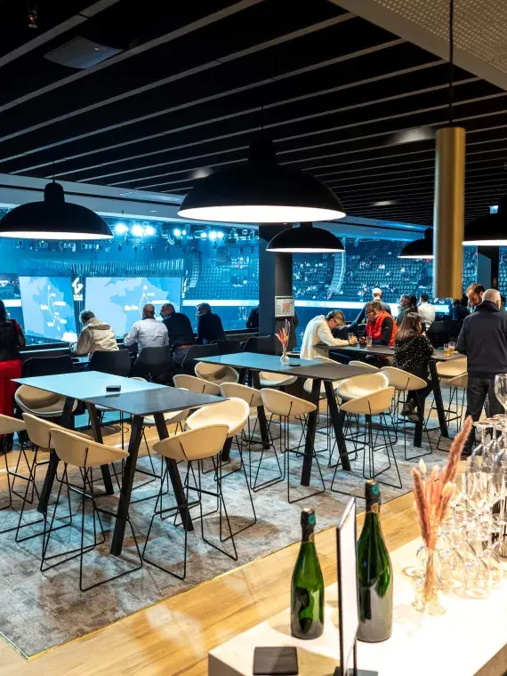 Tables in the Premium Lounge Les Terrasses, offering an elegant setting with comfortable seating and exclusive services for guests