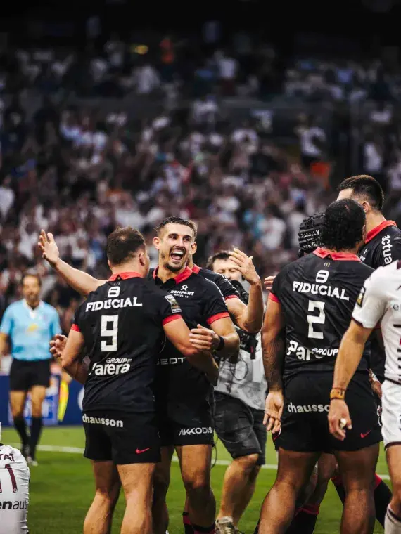 Players in motion during a Top 14 match, seen from the hospitality area