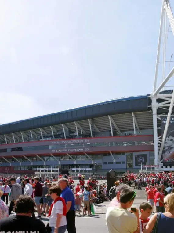 Façade du Principality Stadium de Cardiff baignée de soleil, avec des supporters rassemblés avant un match du Tournoi des 6 Nations
