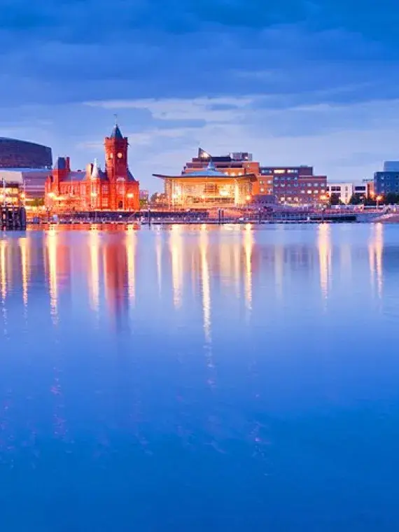 Vue panoramique de Cardiff Bay au coucher du soleil, avec ses quais animés, ses bâtiments modernes et l’ambiance maritime
