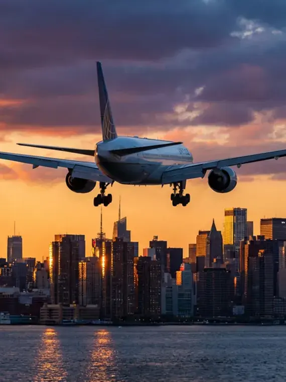 Avion survolant la skyline de New York, symbole du voyage exceptionnel proposé par Sodexo Live! Hospitality.