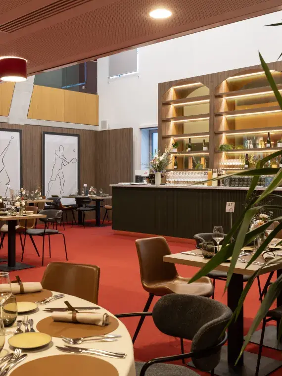 Empty Club des Légendes lounge set in a premium VIP atmosphere, with elegantly arranged tables prepared for guests.