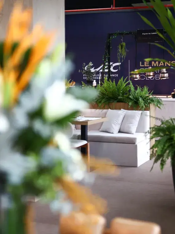 Une zone détente raffinée mêlant mobilier design, végétation et espace bar pour les visiteurs VIP.