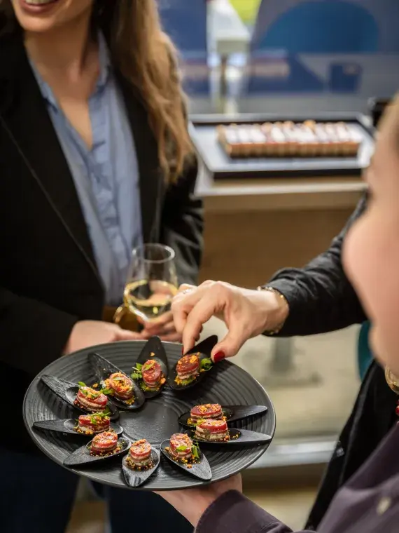Atelier culinaire et cocktail dînatoire haut de gamme proposés dans un salon partagé avec vue sur le Groupama Stadium.