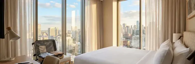 Chambre d’hôtel lumineuse avec vue sur New York, mettant en avant l’expérience haut de gamme des voyages Sodexo Live! Hospitality.