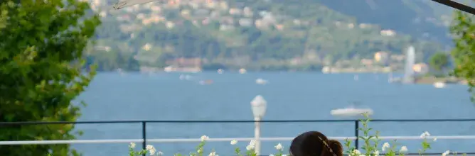 Restaurant en plein soleil au bord du lac de Côme, avec terrasse lumineuse et vue panoramique, illustrant le moment gastronomique inclus dans les offres VIP de Sodexo Live! Hospitality.