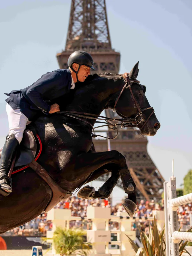 Cavalier en action sautant un obstacle lors du Longines Paris Eiffel Jumping.