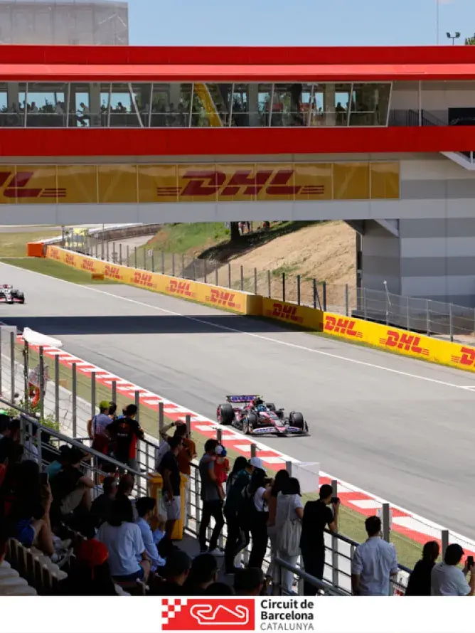 Vue imprenable depuis les gradins sur le circuit du Grand Prix de Formule 1 en Espagne, capturant l’intensité de la course et l’ambiance électrique des tribunes.