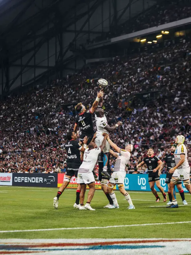 Joueur en pleine touche lors de la finale du Top 14 2024 entre Stade Toulousain et UBB – intensité du jeu captée depuis les espaces VIP Sodexo Live!