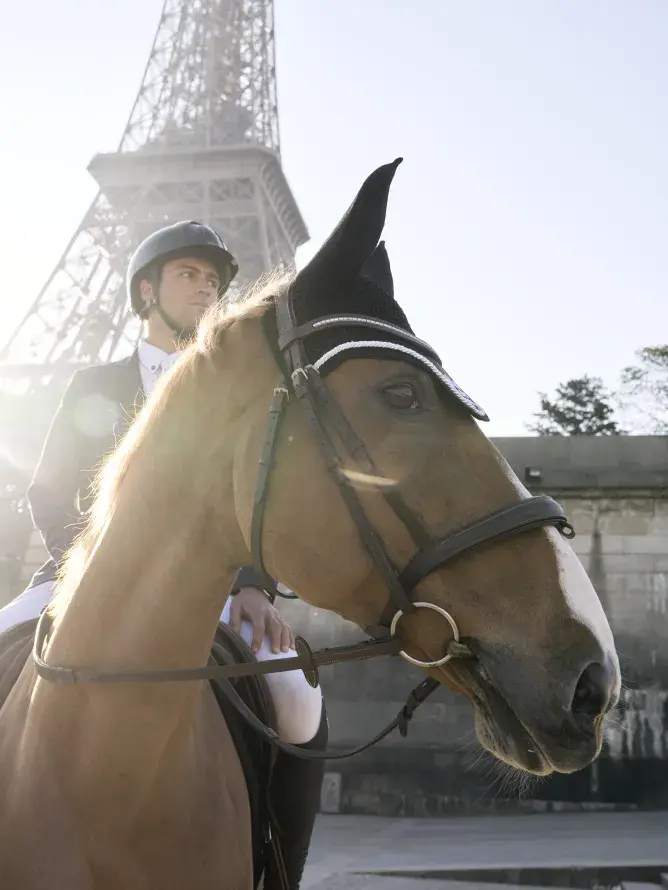 Cavalier à cheval devant la Tour Eiffel, scène majestueuse mêlant art équestre et patrimoine parisien, reflet du prestige des expériences VIP proposées