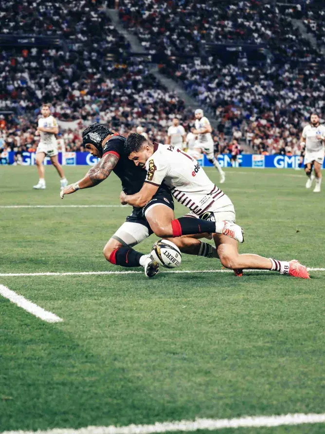 Romain Buros plaque Pita Ahki lors de la finale du Top 14 2025 entre le Stade Toulousain et l’UBB – intensité du jeu captée depuis les espaces VIP Sodexo Live!
