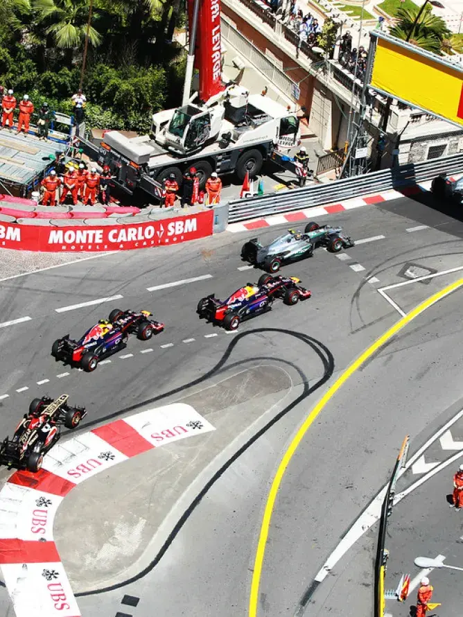 Voitures de courses de Formule 1 négociant un virage serré à Monaco pendant le Grand Prix, avec une offre hospitalité VIP premium