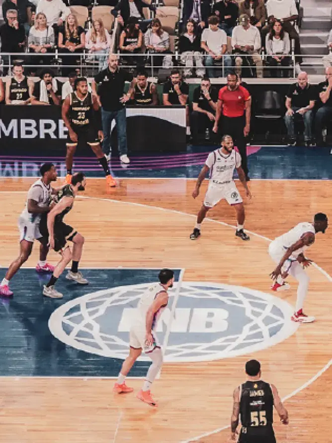 Match de la Supercoupe LNB en cours avec joueurs en action sur le terrain dans le cadre des expériences VIP Sodexo Live! Hospitality