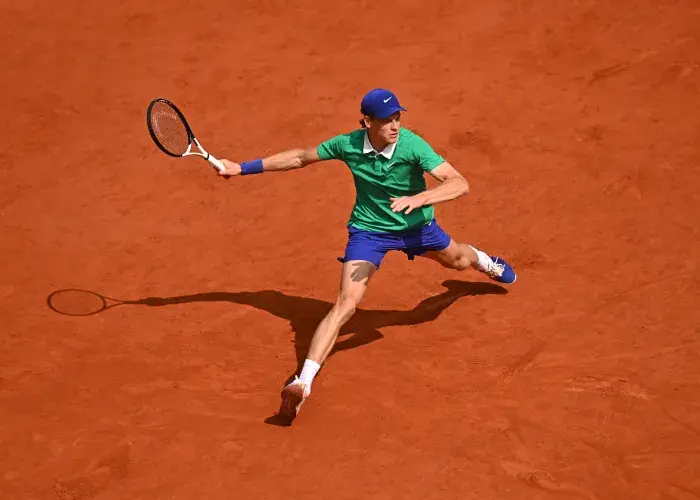 Jannik Sinner in motion to strike a forehand on the Roland-Garros court, during an event where Sodexo Live! Hospitality delivers high-end VIP hospitality solutions.